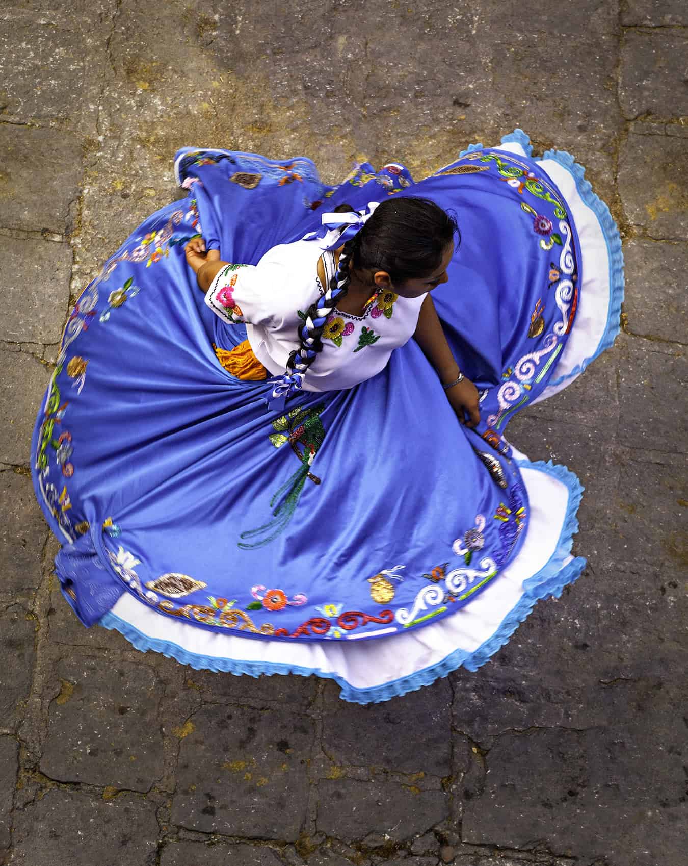Blue Dress Vibrant traditional Mexican dress worn by a dancer in San Miguel, featuring colorful embroidery and full skirt.