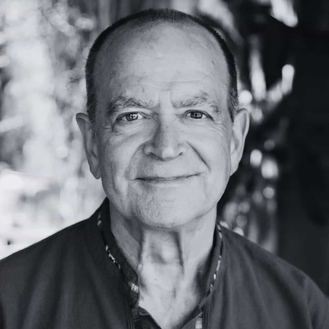 Smiling older man wearing a checkered shirt and zip-up sweater, professional portrait for SMCF by by photographer Ted Davis.
