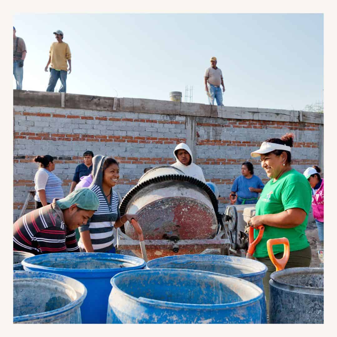 Construction workers pouring concrete at a building site, featuring a SMCF Nonprofit Network Member organization.