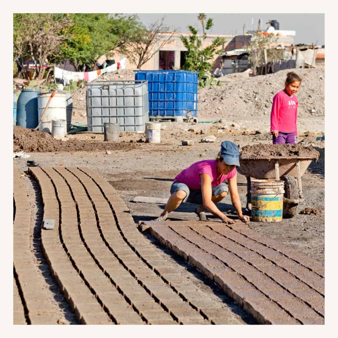 Construction workers laying bricks in a community project, featuring a SMCF Nonprofit Network Member organization.