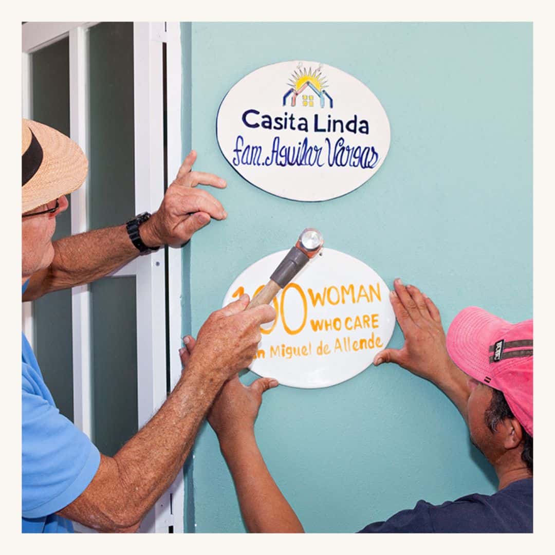 Community members installing signs on a new home, featuring a SMCF Nonprofit Network Member organization.