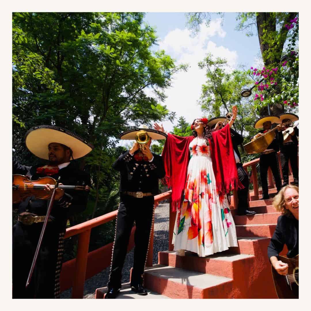 Mariachi musicians playing traditional instruments on steps during a cultural event.
